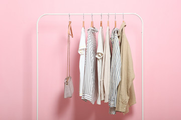 Wall Mural - fashionable clothes on hangers on a wardrobe rack on a colored background.