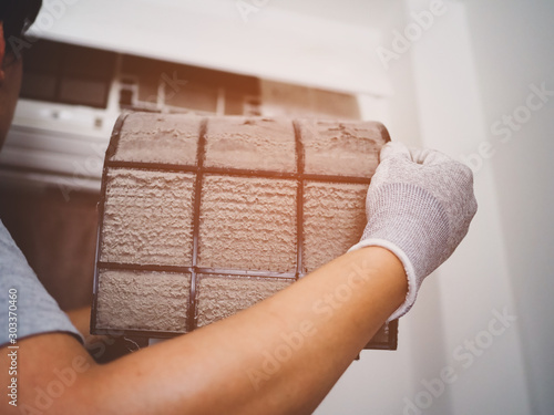Cuadros en Lienzo Men cleaning the filter of air conditioner interior of the house
