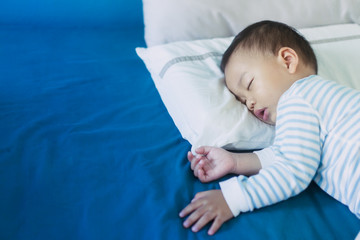 Wall Mural - Baby sleeping in bed and dream.Asian 2 years old baby boy sleep on the bed in bed room.Night time,peaceful and growth hormone concept.