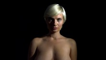 topless blonde lady in dark cover her face, still medium close up shot