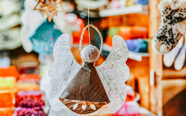 Wall Mural - Handmade linen angel hanging at the Christmas market at old Riga, Latvia. Europe on winter. Street Xmas and holiday fair. Advent Decoration and Stalls with Crafts Items on Bazaar