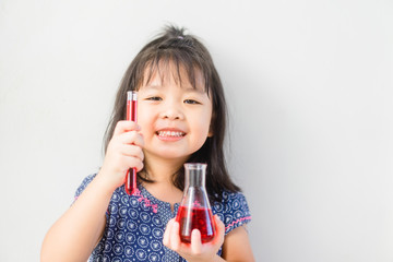 Wall Mural - Happy Little scientist asian girl with red liquid into flask on white background. Home school girl learning about science and pouring reagent into flask.Chemistry class at home.