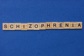 word schizophrenia made from brown wooden letters lies on a blue table