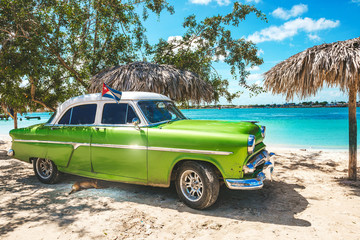 Wall Mural - Playa La Herradura, Cuba - October 27, 2019: American classic car on the beach Playa La Herradura, Province Las Tunas, Cuba