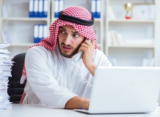 Arab businessman working in the office doing paperwork with a pi