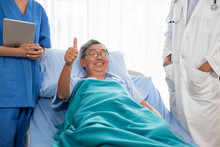 Asian Patient Man Smiling And Lying Down On Hospital Bed In The Hospital Room