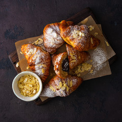 Breakfast croissant with chocolate on a dark stone background top view