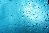 Fototapeta Natura - Close up rain droplets on car windshield over blurred blue sky, rainy season abstract water drops background.