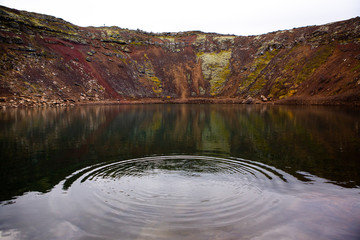 Kerid volcanic crater lake in Iceland. Landscape with red volcanic stones on the top of Kerid Crater with blue crater lake in Iceland