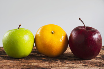 Fresh red green apple and orange over gray black background - fresh fruit background concept