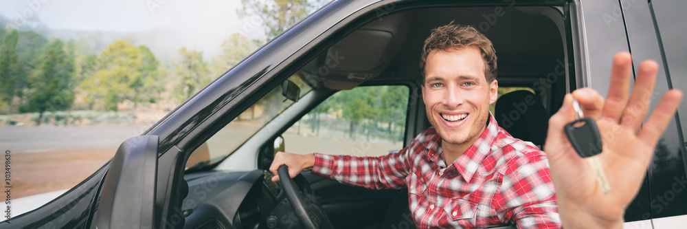 New car young man driver happy holding keys driving rental on road trip vacation travel holiday banner panoramic background. Drive lifestyle. - obrazy, fototapety, plakaty 