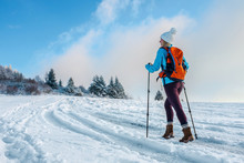 Happy Woman Tourist Walking On The Snowy Trek On The Peak Of Mou