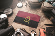 Angola Flag Between Traveler's Accessories on Old Vintage Map. Tourist Destination Concept. Tourist Destination Concept.
