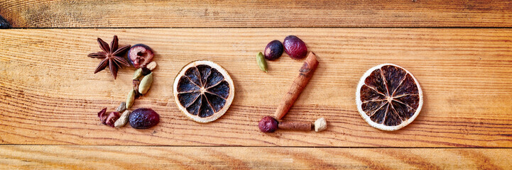 Wall Mural - 2020 written with Christmas spices and dried fruits on panoramic wooden background, new year greeting card