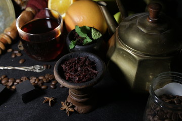 bowl with tobacco for hookah. fruits on a black background. smoking hookah