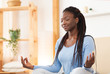 African American Woman Meditating In Bed At Home