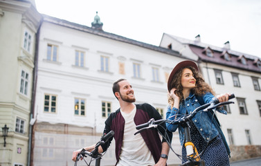Wall Mural - young tourist couple travellers with electric scooters in small town.