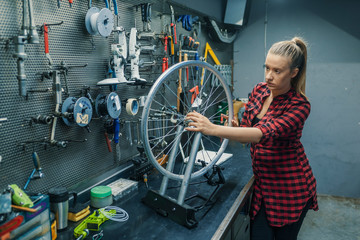 Wall Mural - Caring for you wheels. Woman mechanic working in the garage