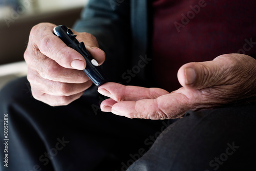 Fotomural old man about to measure his blood glucose level