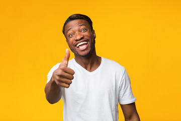 Sticker - Positive Black Man Gesturing Thumbs Up Standing Over Yellow Background