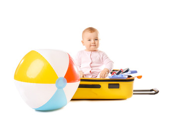 Wall Mural - Cute baby with inflatable ball and suitcase on white background