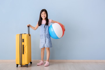 Sticker - Cute girl with suitcase and inflatable ball near color wall