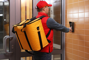 Sticker - Male courier with thermo bag pushing intercom button. Food delivery service