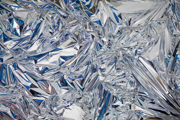 Decoration background of metal crumpled foil, shiny silver surface