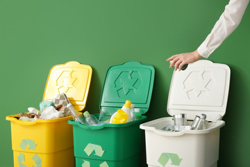 Woman throwing garbage into container. Recycling concept