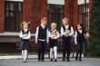 Group of kids in school uniform that is outdoors together near education building