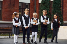 Group Of Kids In School Uniform That Is Outdoors Together Near Education Building
