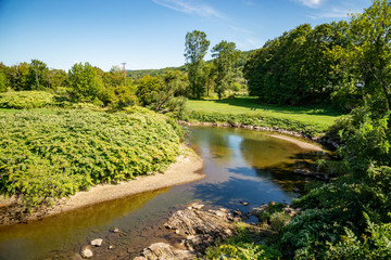 A colorful landcape reflected in the Little River in Stowe, Vermont