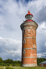 Wall Mural - Lighthouse and house in the Baltic Sea. Shore, evening light, sunset, clouds and architecture concept. Mohni, small island in Estonia, Europe.