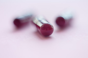 Wall Mural - three brown pills on a pink background