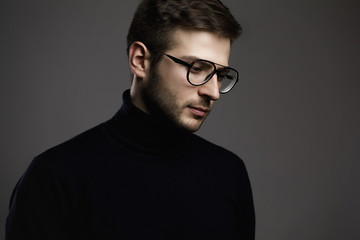 Wall Mural - Young smart man wearing glasses and a folded polo neck