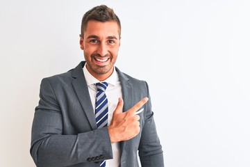 Canvas Print - Young handsome business man wearing suit and tie over isolated background cheerful with a smile on face pointing with hand and finger up to the side with happy and natural expression