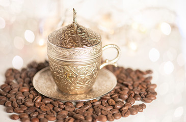  Traditional turkish coffee cup and black coffee beans ,on the abstract glitter background.