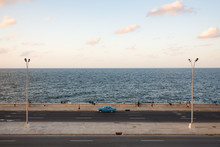 People And Cars Cruise Along The Malecon In Havana
