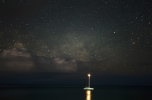 Yacht In The Sea On A Background Of Stars And Clouds