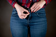 woman holds on zipper on jeans