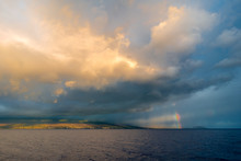 A Storm And Rainbow Over An Island