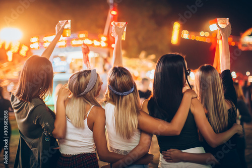 Fotografía Back view of group of girls having fun at the music festival