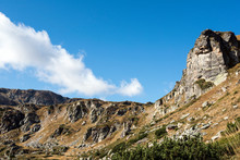 Panorama Of The Mountain Range. Light White Clouds Float Over The Mountains, Sunny Weather, Morning. At The Foot Of The Mountains, A Forest Grows. Seven Rila Lakes, Bulgaria