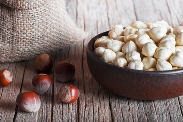 Wall Mural - Hazelnuts, filbert in bowl on wooden table. heap or stack of hazel nuts. Hazelnut background, healty food