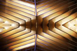 Close-up photo of wooden lath structure.  Reworked modern architecture or minimal interior fragment. Geometric background glowing in darkness. Irregular grid pattern in golden color.