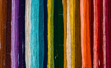 Colorful rainbow of freshly hand dyed yarn hanging on a wall