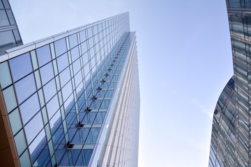 Modern office building wall made of steel and glass with blue sky