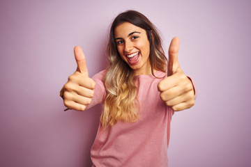 Sticker - Young beautiful woman wearing a sweater over pink isolated background approving doing positive gesture with hand, thumbs up smiling and happy for success. Winner gesture.