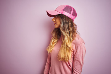 Poster - Young beautiful woman wearing cap over pink isolated background looking to side, relax profile pose with natural face with confident smile.