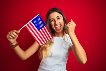 Poster - Young woman holding united states of america flag over red isolated background screaming proud and celebrating victory and success very excited, cheering emotion